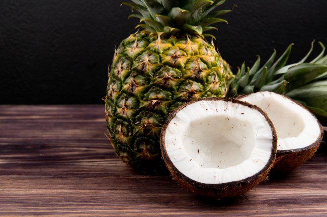 side-view-of-half-cut-coconut-with-pineapple-on-wo-2024-10-14-04-32-38-utc Crédit photo Envato Market / stoockking